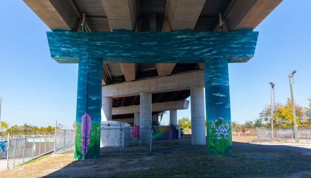 Mural of flowers and the sky under the elevated train tracks across from Main Street at the Burnett Transit Center